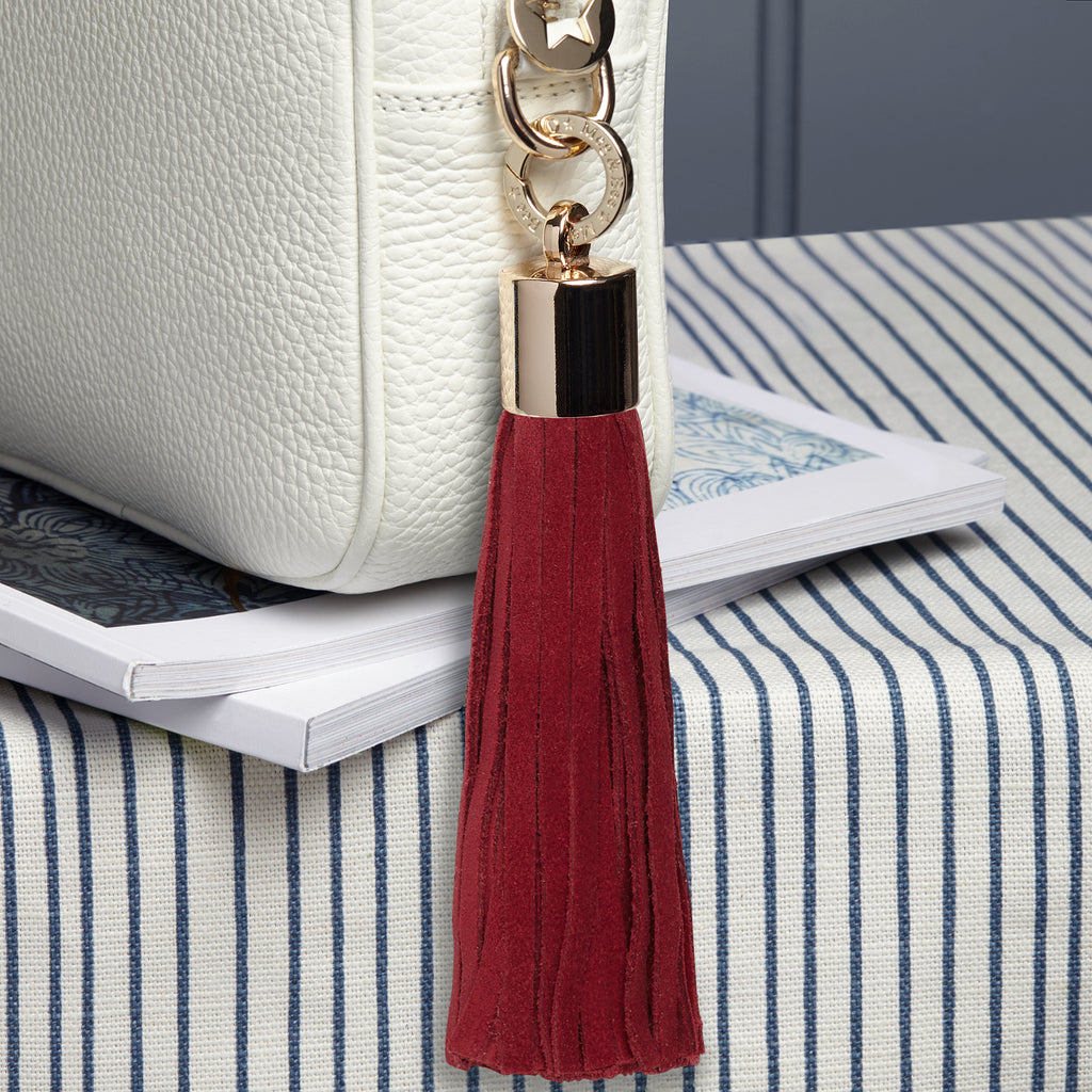 Large Leather removable bag tassel in raspberry suede.  Light gold hardware including light gold charm ring