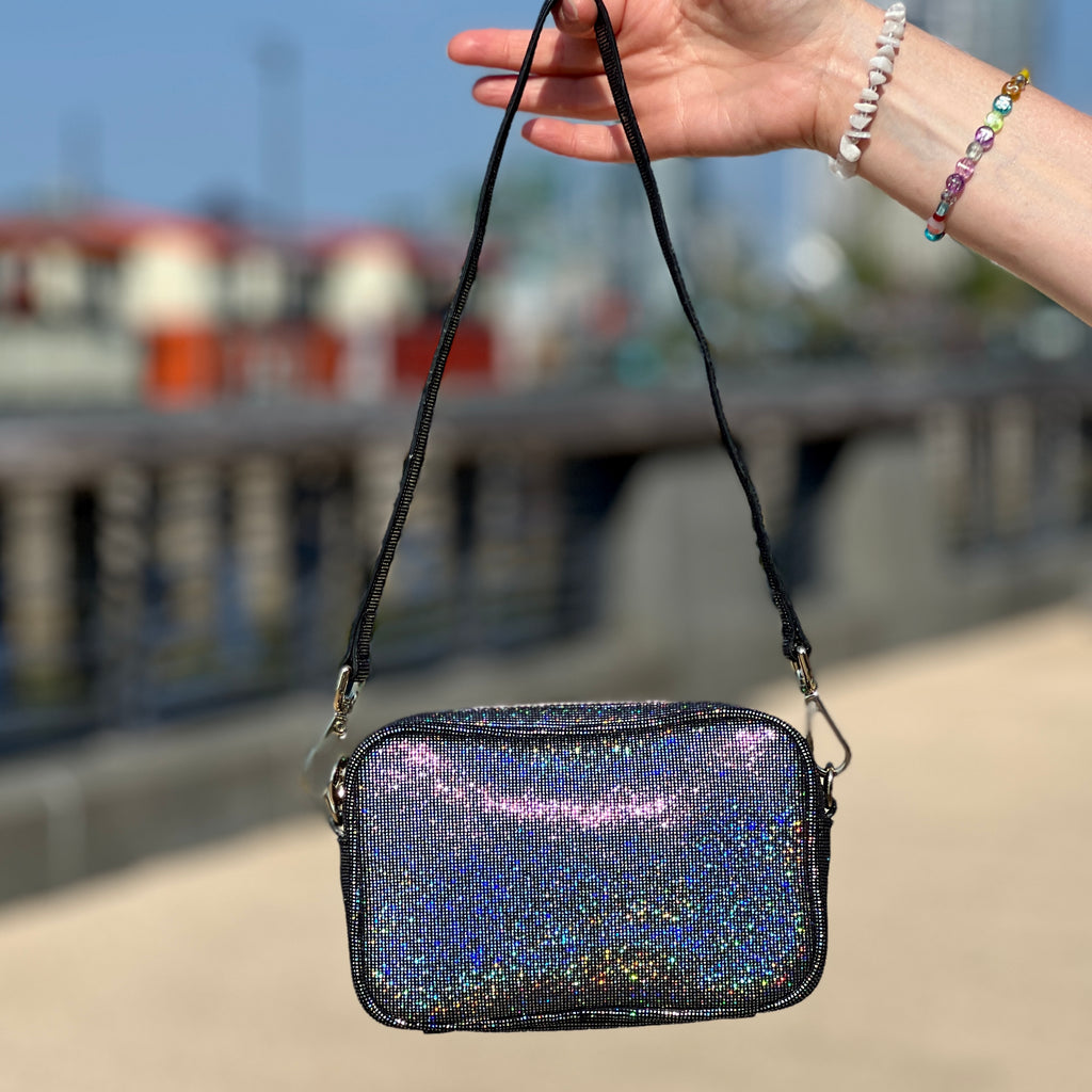 Hand holding sparkly leather handbag