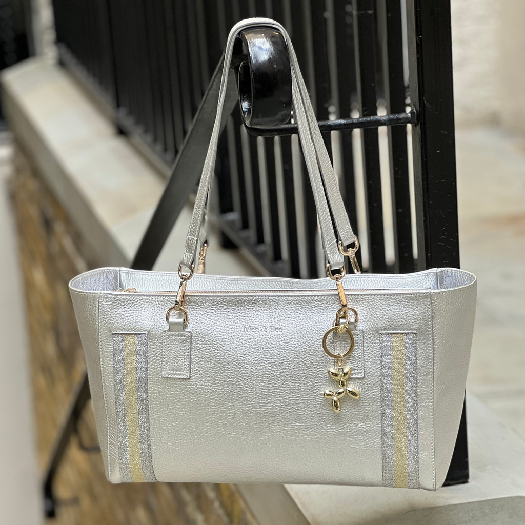 Silver handbag with a keychain on a blurred background