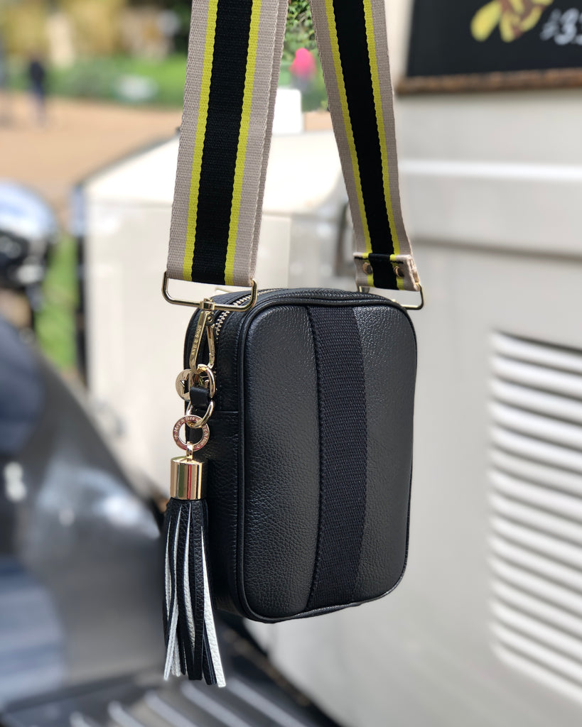 Black camera crossbody bag with interchangeable strap and tassel