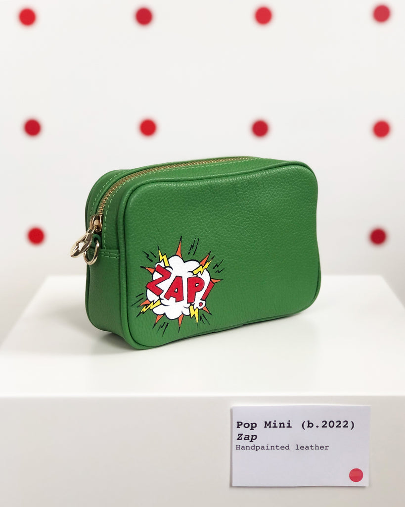 Small Green leather cross body bag with graphic painting phrase 'ZAP' in both left corner.