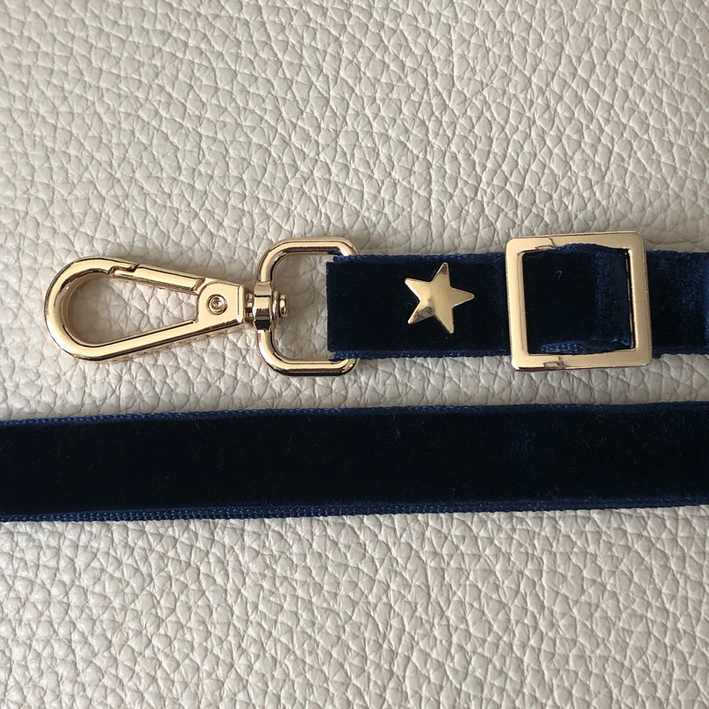 Interchangeable dark blue skinny velvet strap with gold hardware.