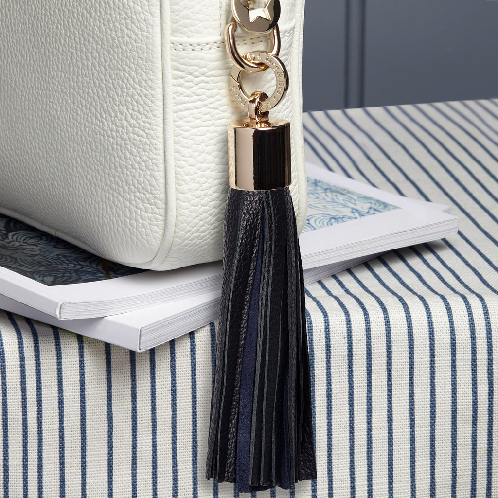 Large black leather and navy suede removable bag tassel with gold hardware and attachable charm ring 