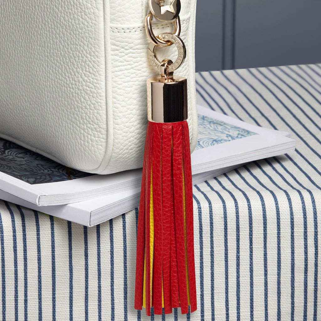 large leather red and yellow removable bag tassel with gold hardware and attachable charm ring 