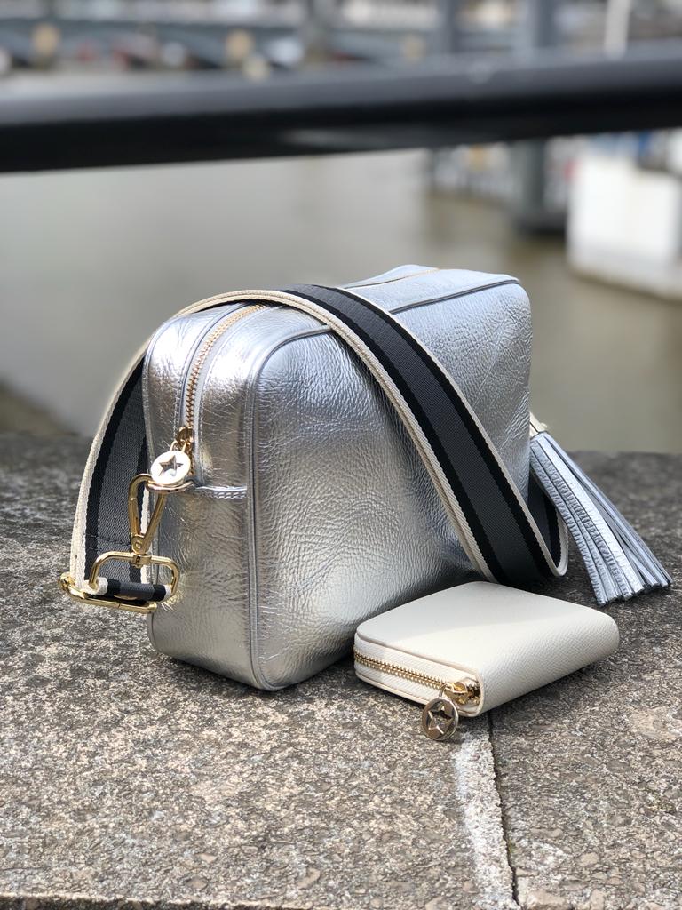 Large silver cross body bag with grey striped strap and small leather cream purse