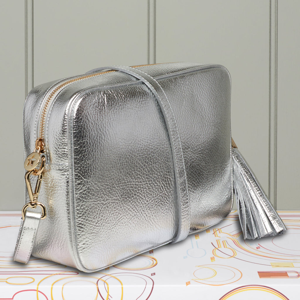 Large silver crossbody bag with matching large leather tassel all with gold hardware