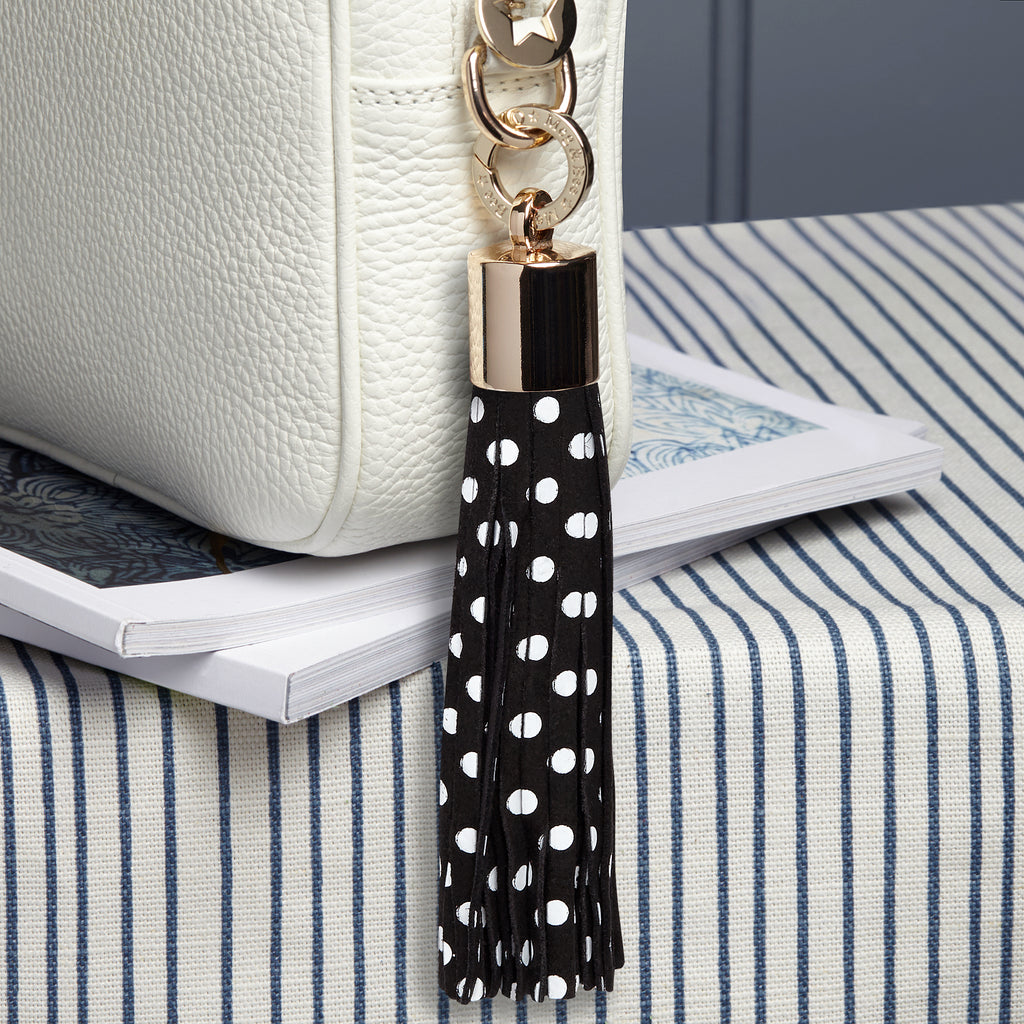 Large leather black and white dot removable bag tassel with gold hardware and attachable charm ring 