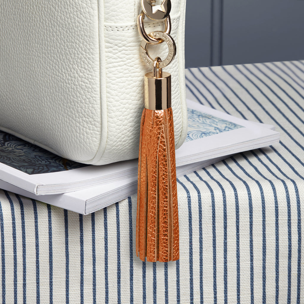 small leather orange metallic removable bag tassel with gold hardware and attachable charm ring 