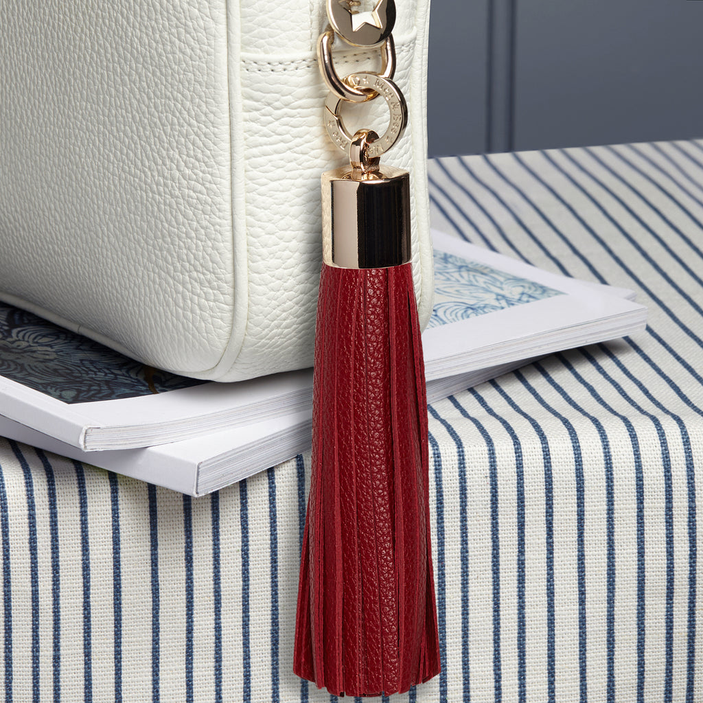 Large leather removable bag tassel in Cranberry. Light gold hardware plus light gold charm ring
