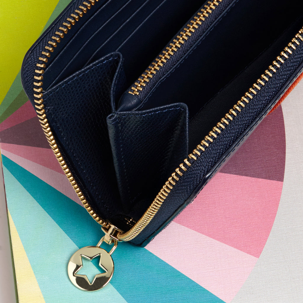 Large rectangular Navy blue leather purse interior with hard holders and pockets for cash and zip compartment for coins all with gold hardware