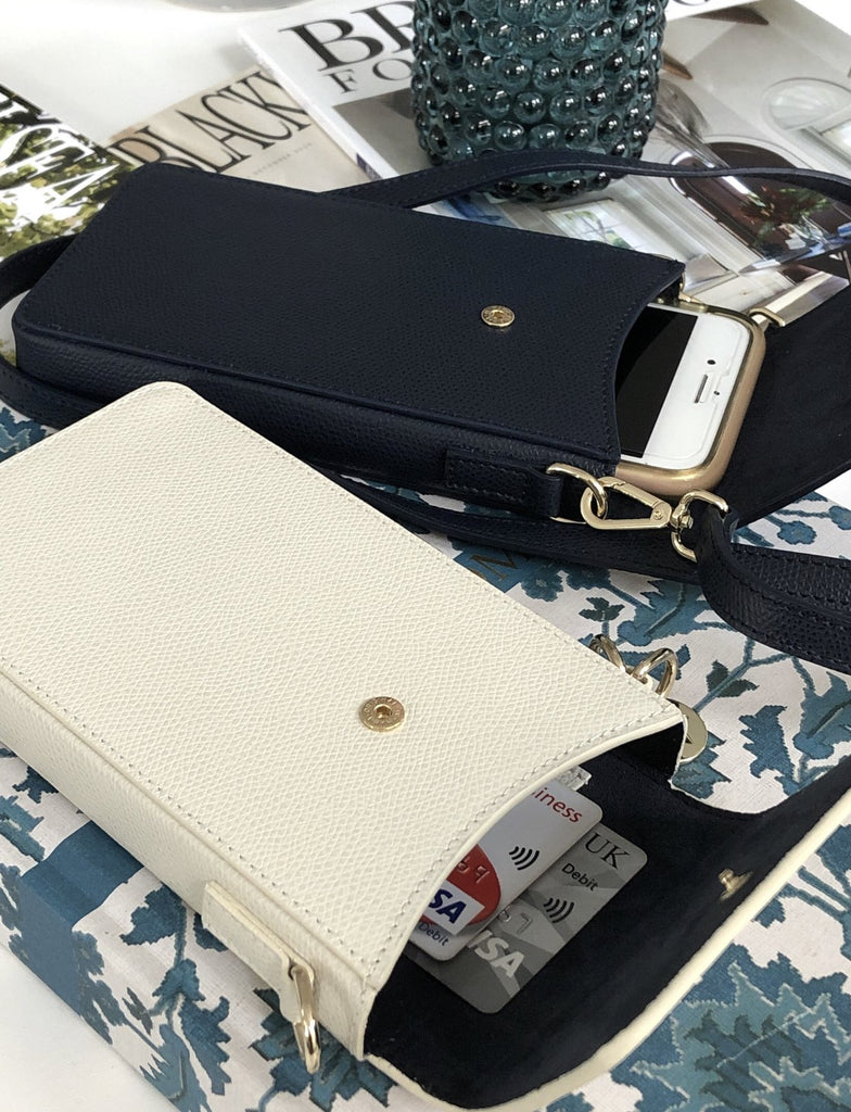 Small leather phone bag showing interior with two card holder pockets.