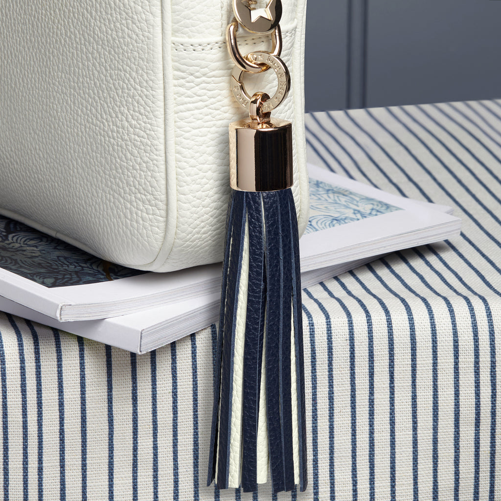 large leather navy and white removable bag tassel with gold hardware and attachable charm ring 